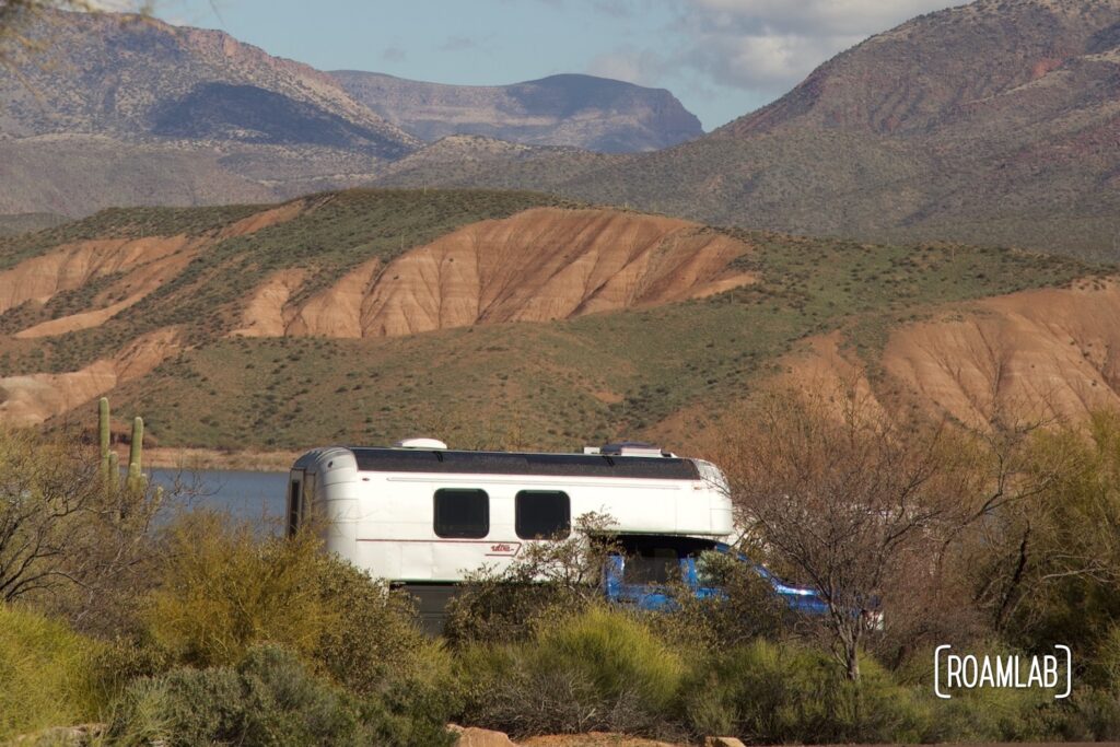 Avion C11 truck camper parked at an overlook near Lake Roosevelt with pink bluffs in the distance.