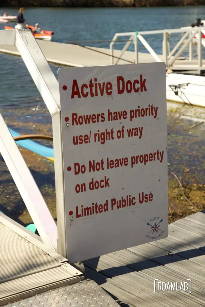 Sign attached to a dock reading: Active Dock. Rowers have prioriity use / right of way. Do Not leave property on dock. Limited public use.