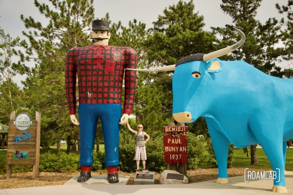Woman holding the hand of Paul Bunyan next to Babe the Blue Ox in Bemidji, Minnesota.