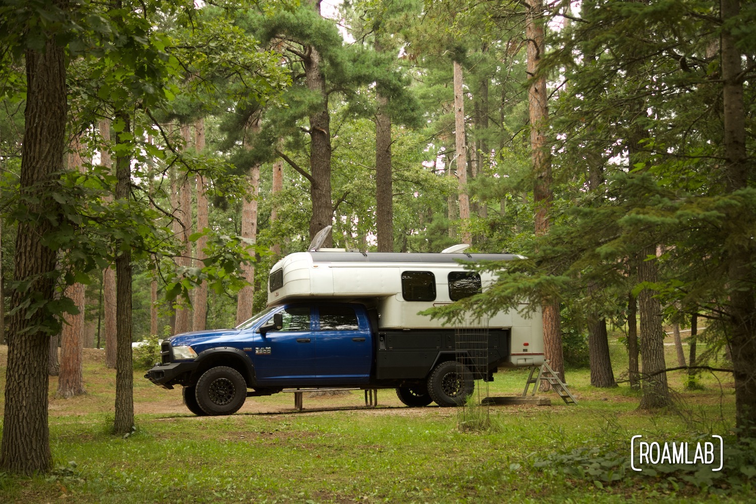 1970 Avion C11 truck camper parked among the woods of Lake Bemidji State Park in northern Minnesota.