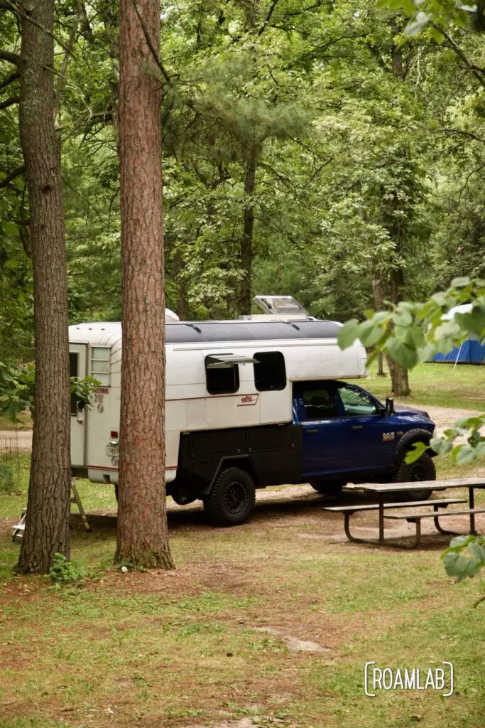 1970 Avion C11 truck camper parked among the woods of Lake Bemidji State Park in northern Minnesota.