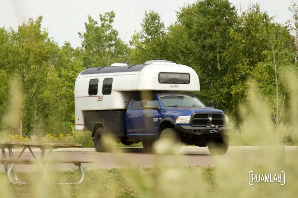 1970 Avion C11 truck camper parked near a picnic table.