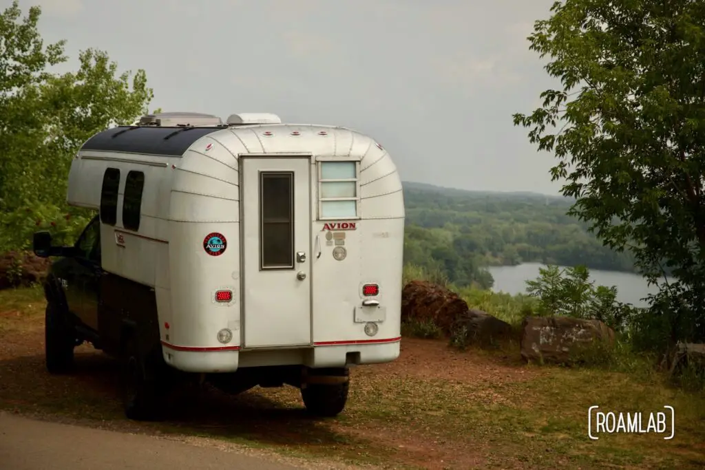 1970 Avion C11 truck camper parked at a scenic overlook.