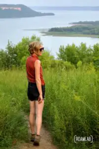 Woman standing in tall grass along a bluff over looking Lake Pepin and the Wisconsin bluffs.