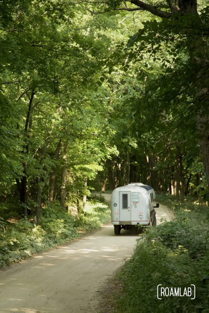 Avion C11 truck camper driving along a gravel forested road.