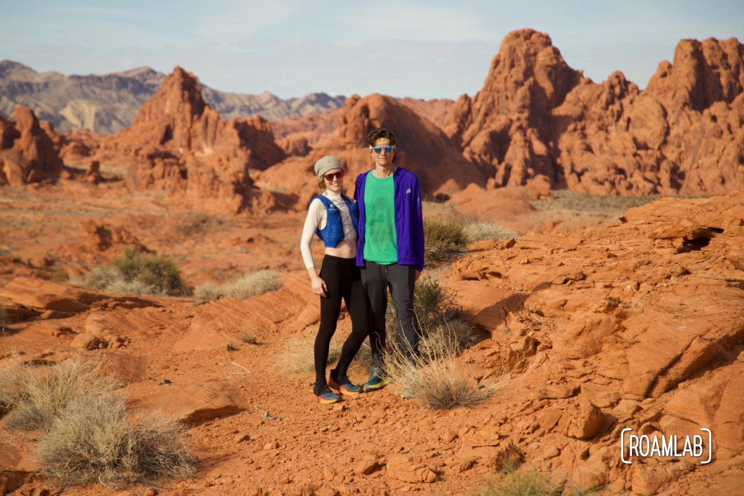 Man and woman trail runners standing together in the desert.