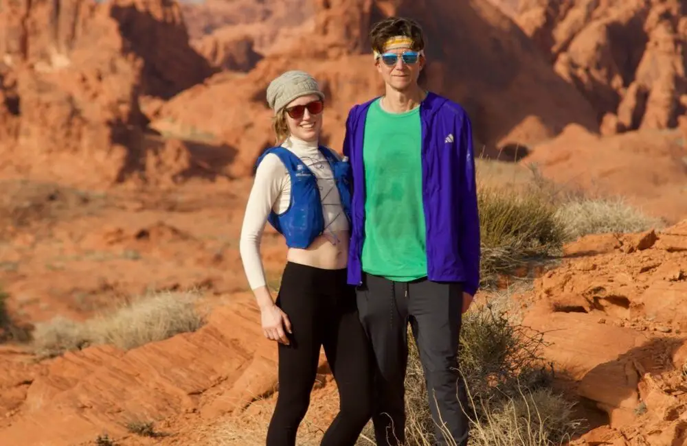 Man and woman trail runners standing together in the desert.