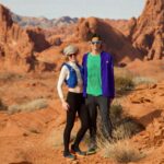 Man and woman trail runners standing together in the desert.