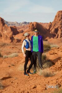 Man and woman trail runners standing together in the desert.