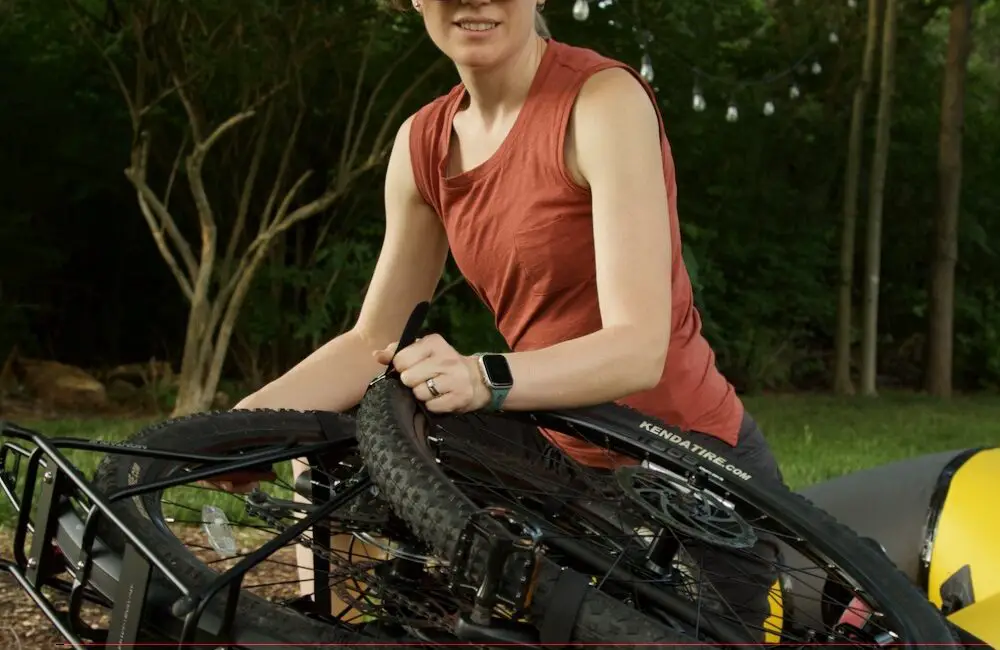 Woman strapping a bicycle to a raft
