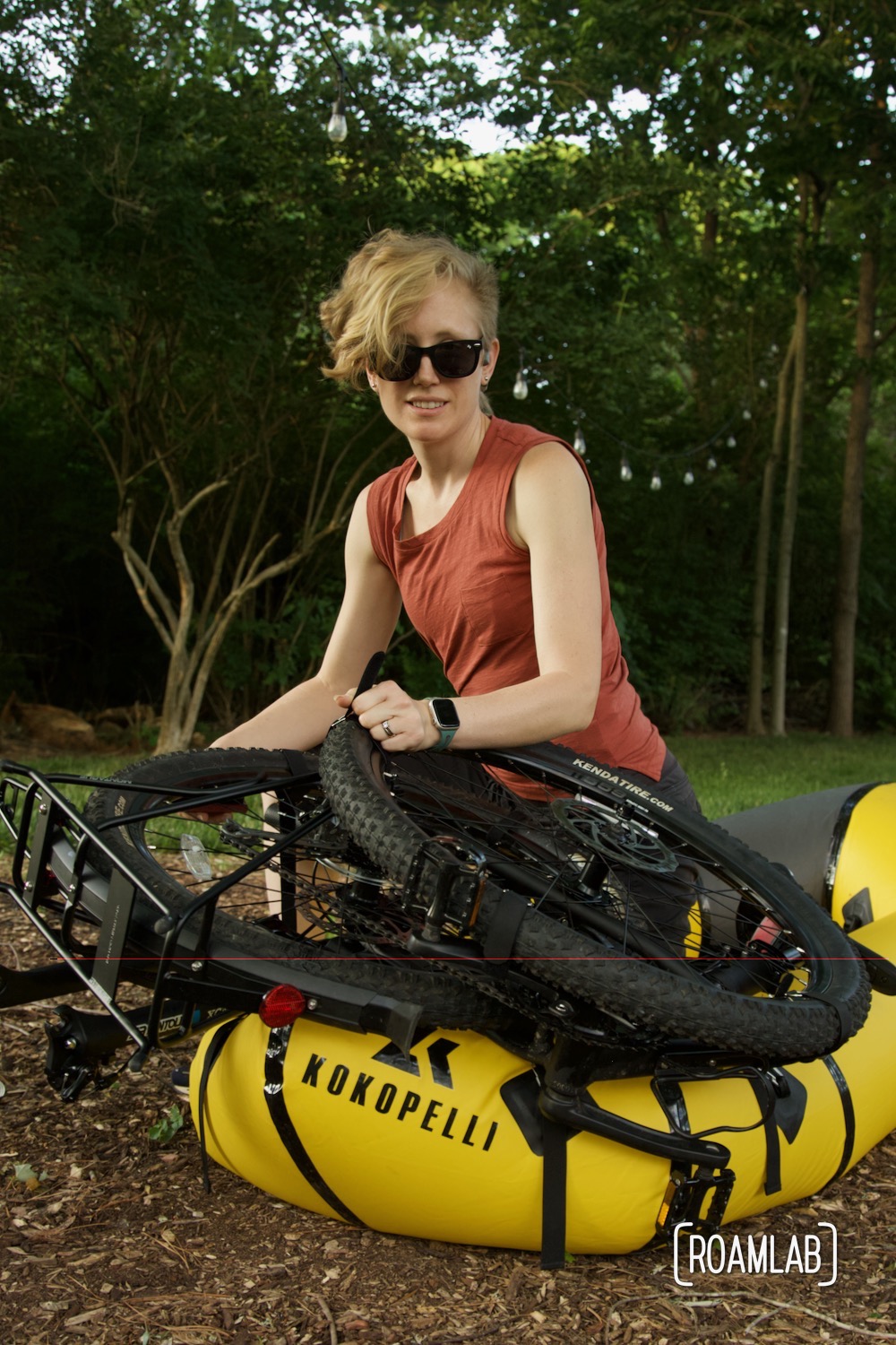 Woman strapping a bicycle to a raft