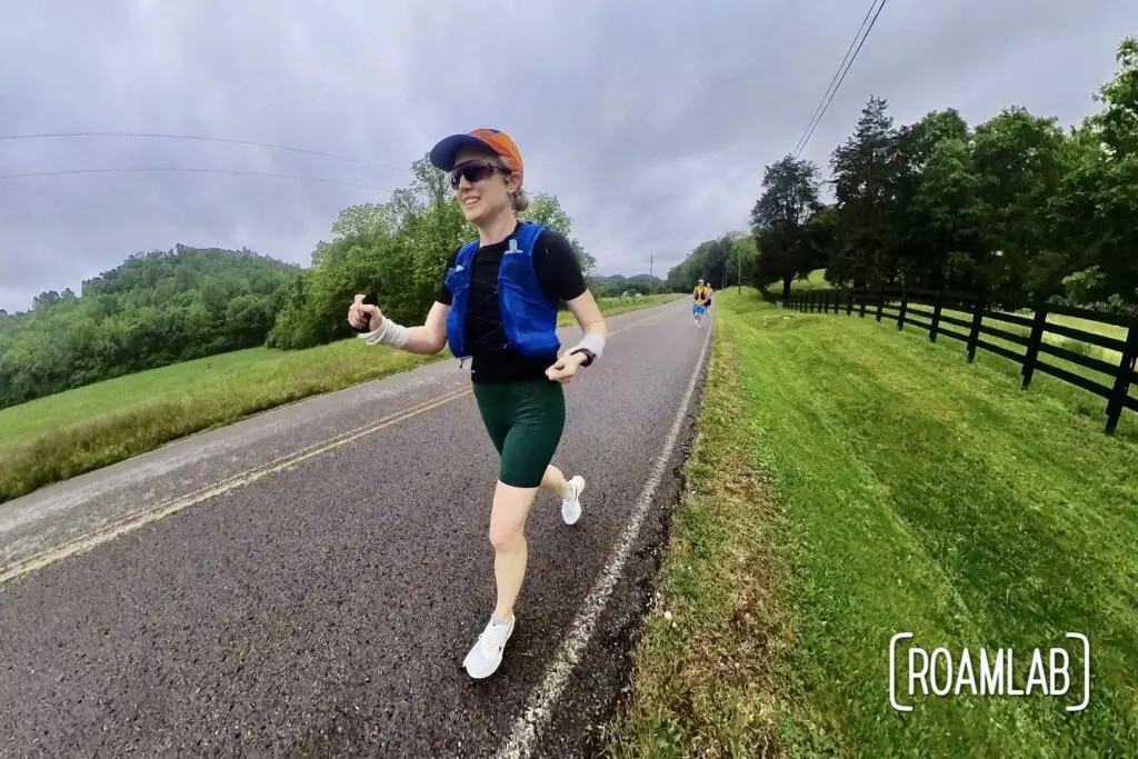 Woman running along the side of a country road.
