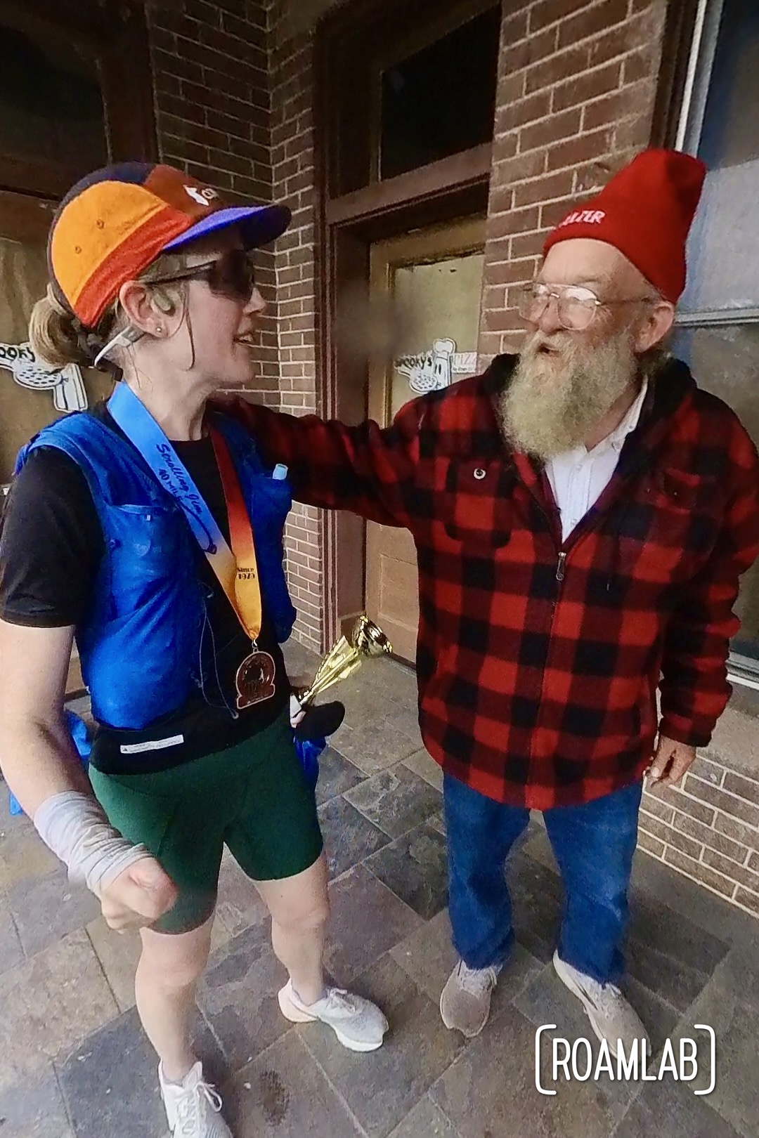 Exhausted woman runner talking with race director at finish line.