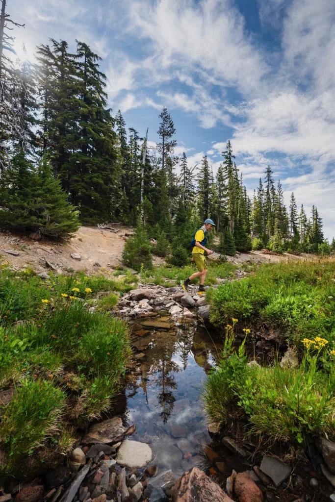Chris crossing a creek along the Oregon Cascades 100 course.