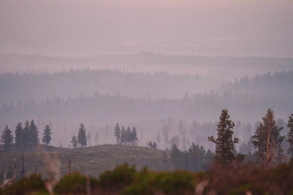 Hazy views of distance ridge lines through wildfire smoke.